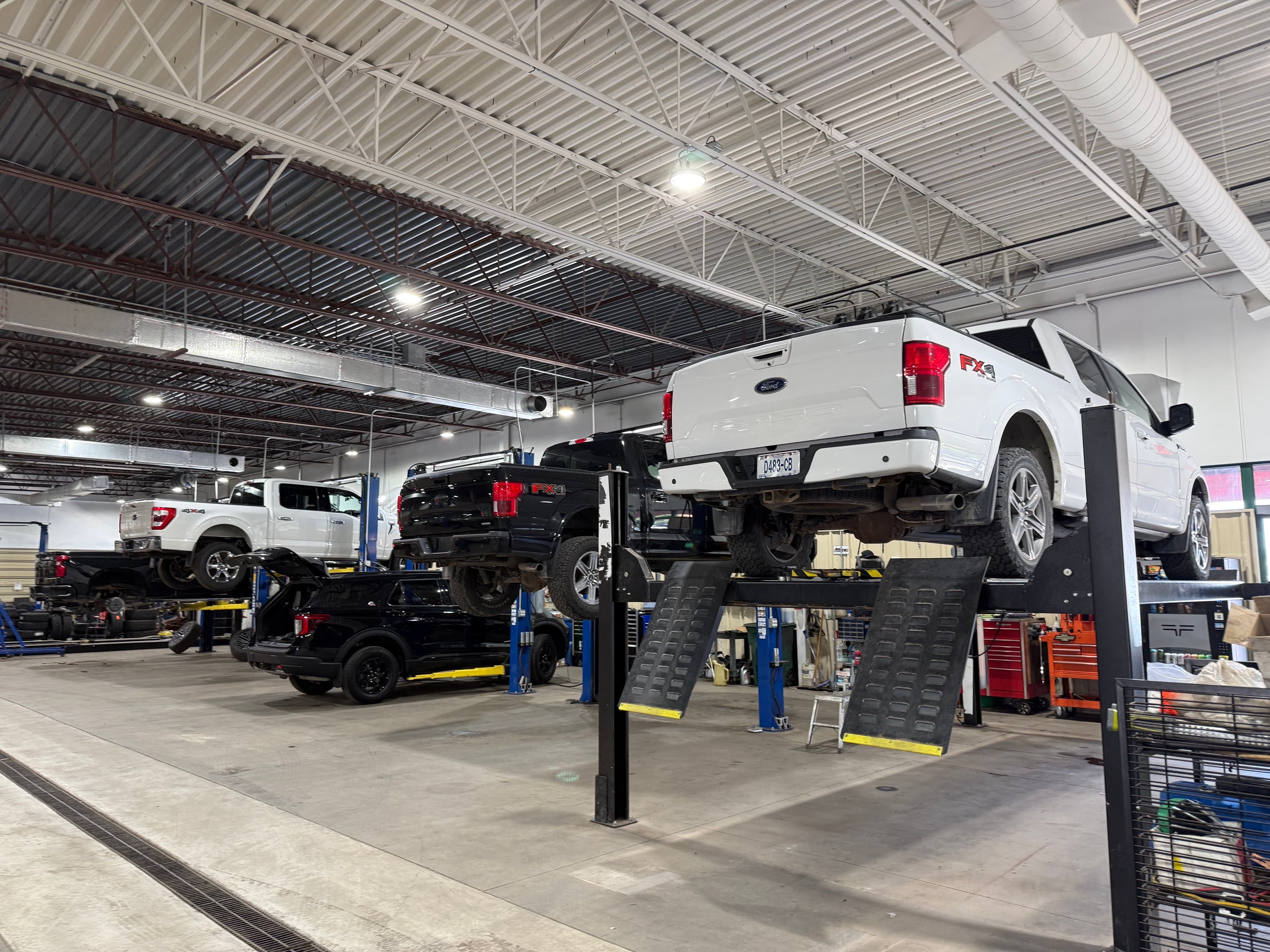 A vehicle raised on the alignment rack inside the Odessa Auto & Truck Repair shop