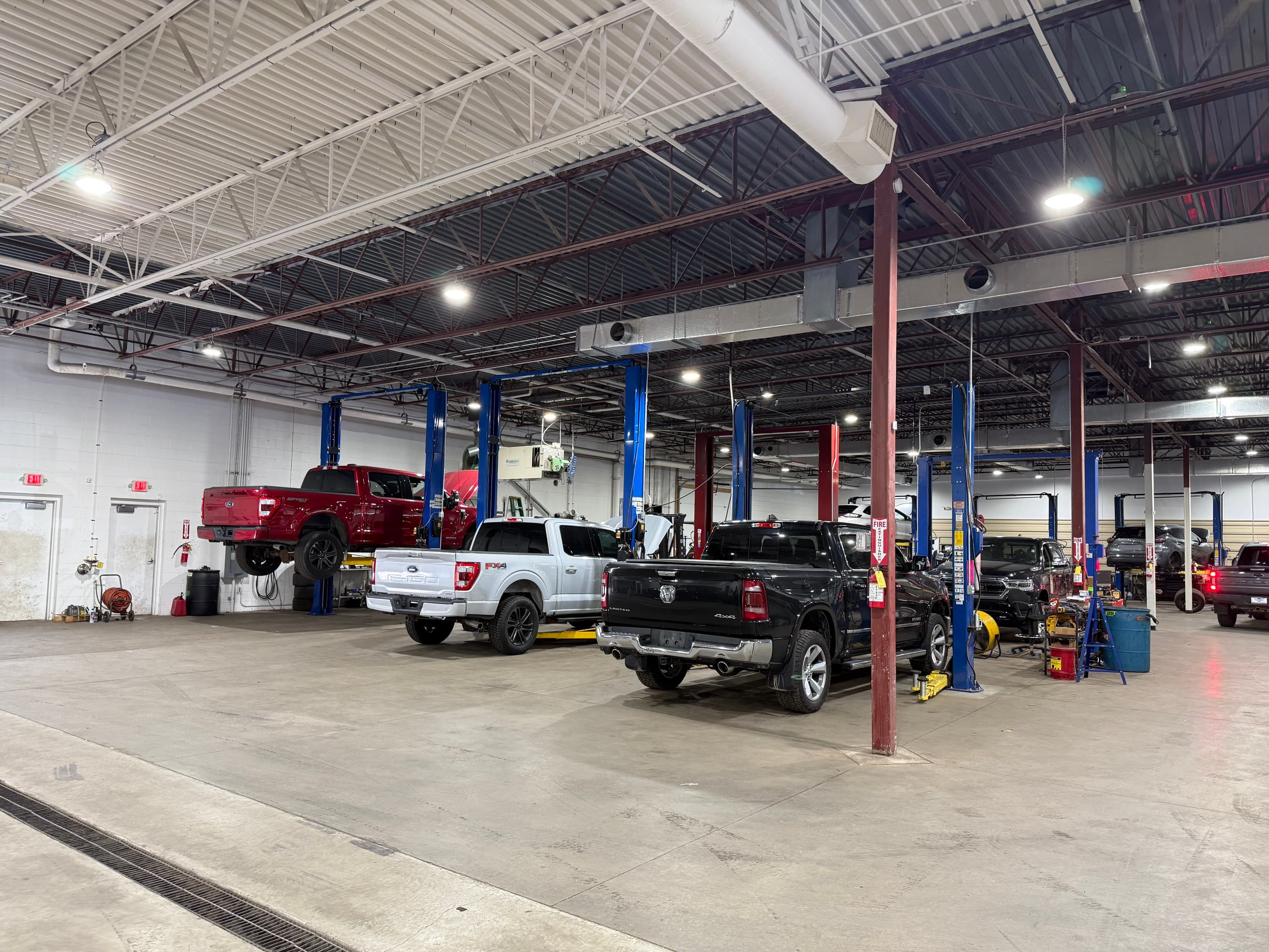 A busy Odessa Auto & Truck Repair service bay with trucks up on the lifts